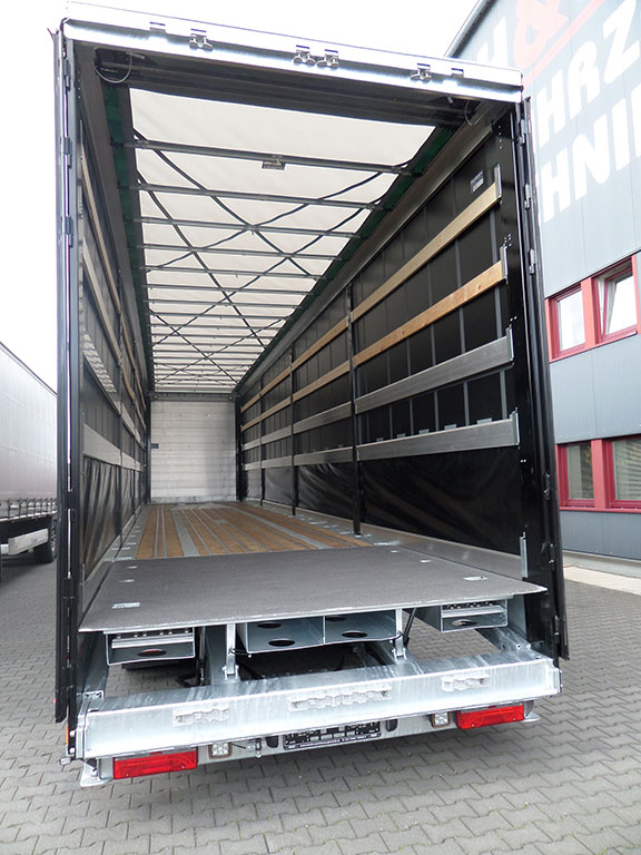 Semi-trailer with lowerable rear and drive-on ramps